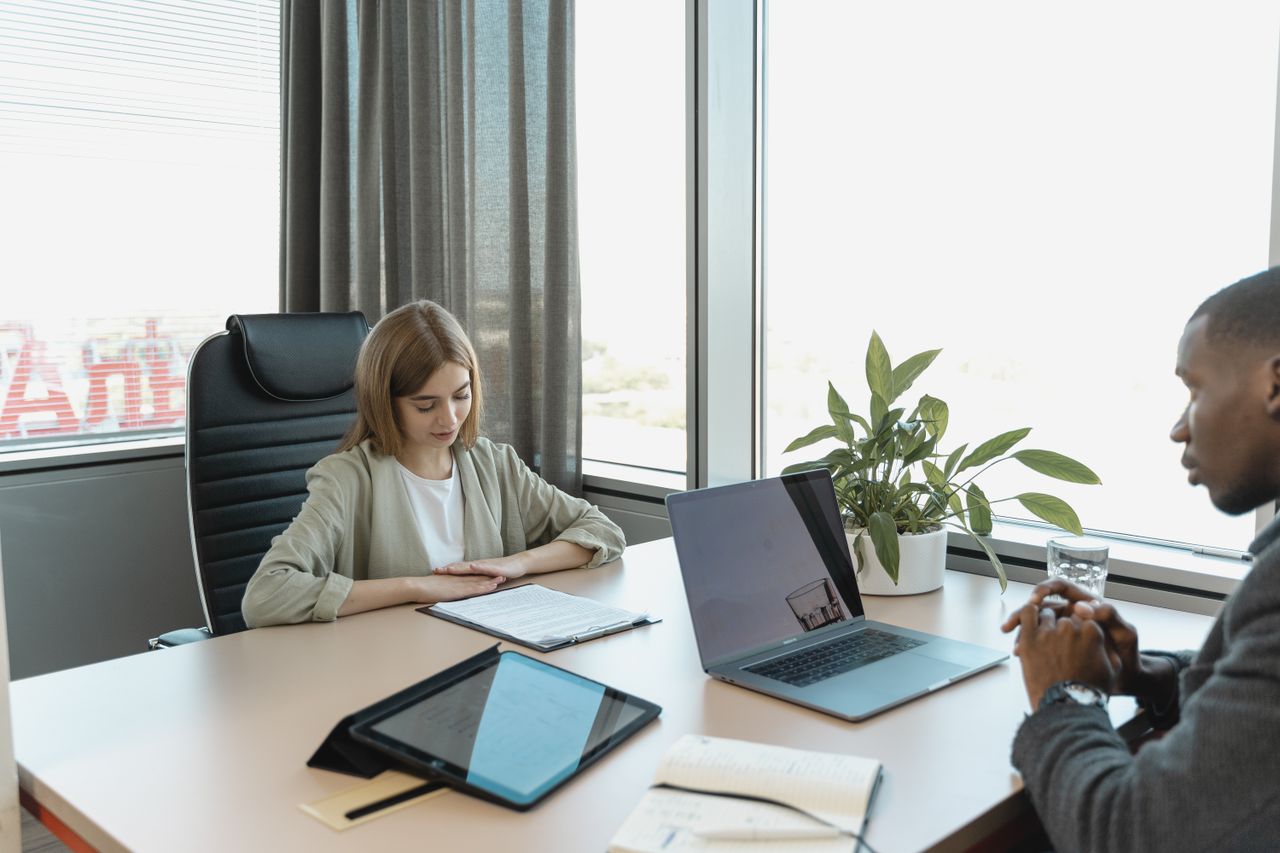 Candidate and interviewers discussing a professional role around a laptop in a real interview setting