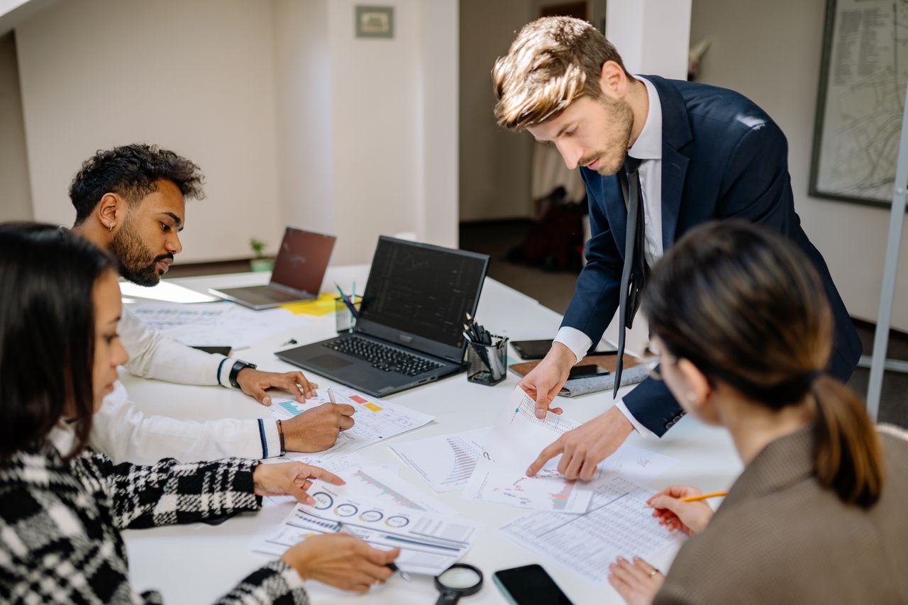 Professional team discussing charts and risk indicators during a real business meeting