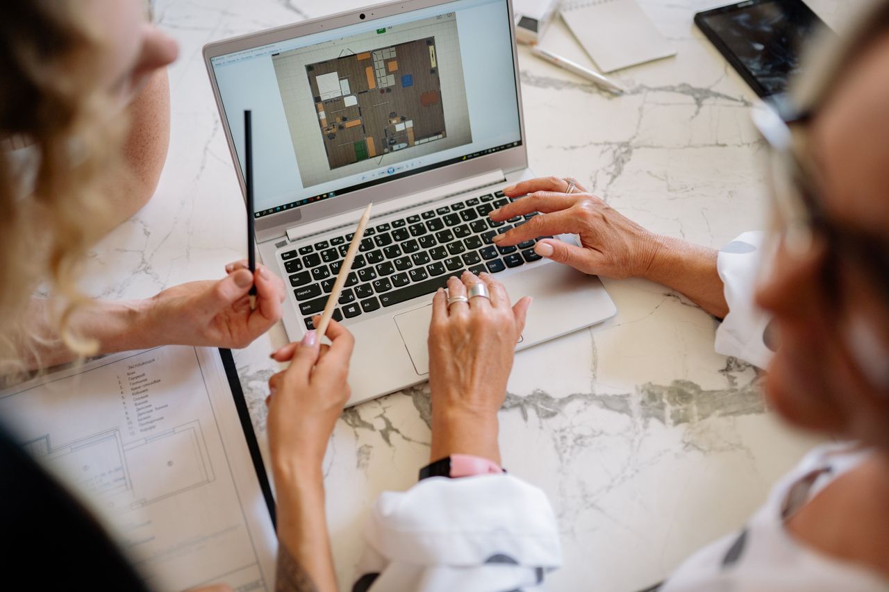 Professional team reviewing a digital workflow on a laptop in a real office